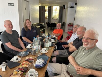 EInige Teilnehmer*innen des Klimacafes BAM sitzen in fröhlicher Runde am Tisch.